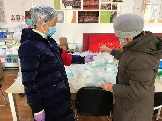 為樓棟分發(fā)口罩，并為包裝袋消毒